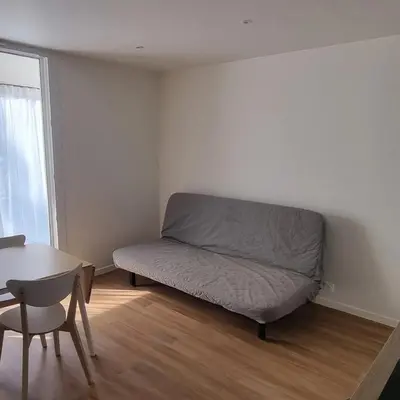 a bed in a room with a table and a chair at Appartement in Aix-en-Provence