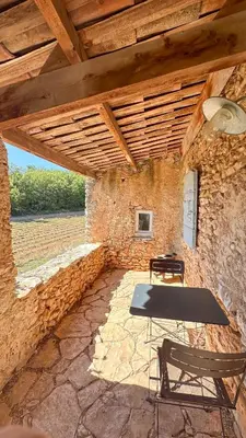 a stone building with a table and two chairs at Hameau de l'Esperelle in Simiane-la-Rotonde