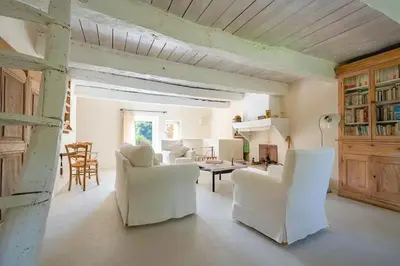 a living room with white chairs and a table at Hameau de l'Esperelle in Simiane-la-Rotonde