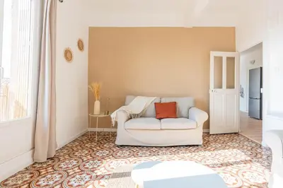 a living room with a white couch and a window at Appartement spacieux, chaleureux & tout confort in Pertuis