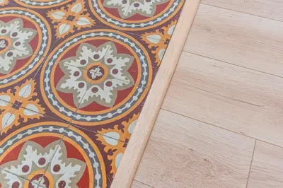 a floor with an orange and white patterned rug at Appartement spacieux, chaleureux & tout confort in Pertuis