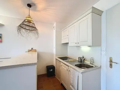 a kitchen with white cabinets and a sink at Superbe appartement dans golf 4 étoiles in Saumane-de-Vaucluse