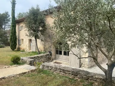 a stone house with a gate in front of it at Authentique Bergerie Coeur Luberon in Lacoste