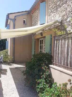 a house with a balcony and a fence at Petit gîte et Grande piscine in Blauvac