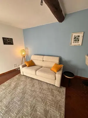 a living room with a white couch and a rug at Aix Centre Rue d'Italie - T2 40m2 Rénové - à 2 pas du Cours Mirabeau in Aix-en-Provence