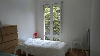 a bedroom with a bed and a large window at Agréable appartement Montfavet Avignon in Avignon