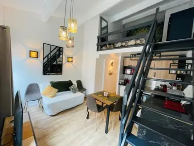 a living room with a couch and a spiral staircase at City break in old center Aix! in Aix-en-Provence