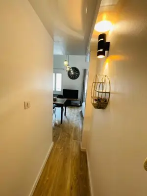 a hallway leading to a living room with a table at City break in old center Aix! in Aix-en-Provence