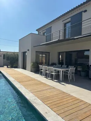 a house with a table and chairs next to a swimming pool at Villa moderne au coeur de la provence in Pernes-les-Fontaines