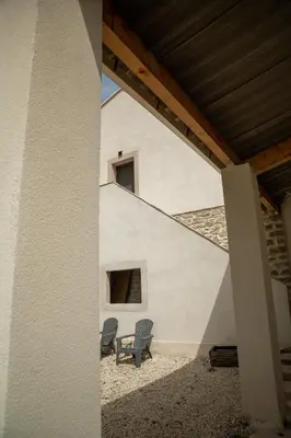 two chairs sitting on a patio next to a building at La Maison PP - Appartements in Carpentras