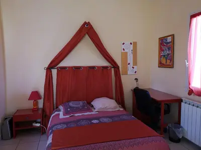 a bedroom with a bed with a red canopy at Chambre d'hôte à Pierrevert, en Haute Provence in Pierrevert