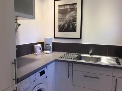 a kitchen with a sink and a washing machine at Le Bois De La Cour in Roussillon