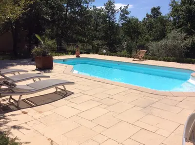 a swimming pool with two lounge chairs next to it at Le Bois De La Cour in Roussillon