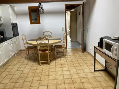 a dining room with a table and chairs in a kitchen at Les Vignes in Maubec