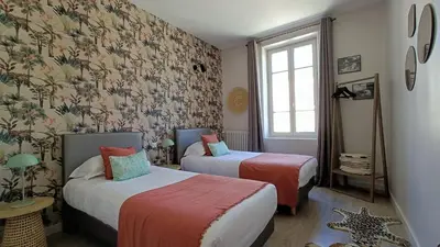 a living room with two chairs and a table with a vase at La Cour Des Sens in Lagnes