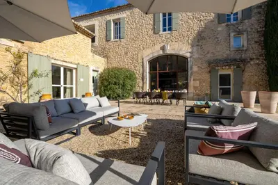a patio with couches and a table in front of a building at La Cour Des Sens in Lagnes