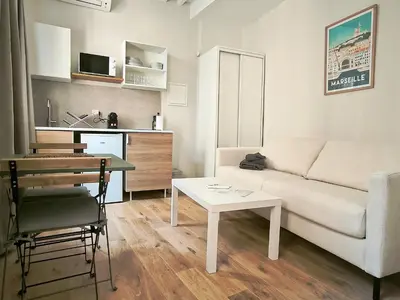 a living room with a couch and a table at New! Le zola studio lumineux en centre ville in Aix-en-Provence