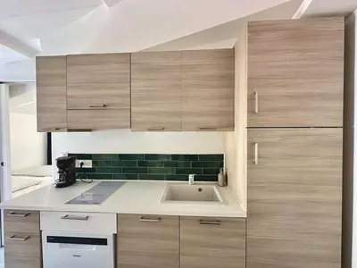 a kitchen with wooden cabinets and a sink at Charmant T2 à deux pas du cours Mirabeau in Aix-en-Provence