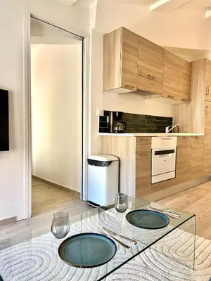 a kitchen with two plates on a glass table at Charmant T2 à deux pas du cours Mirabeau in Aix-en-Provence