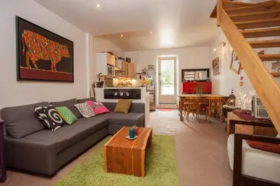 a living room with a couch and a table at Maison dans un coin de verdure proche de la Sorgue in LʼIsle-sur-la-Sorgue
