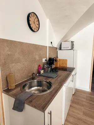 a kitchen with a sink and a clock on the wall at Cosy Cœur Alpilles, T2 neuf in Aureille