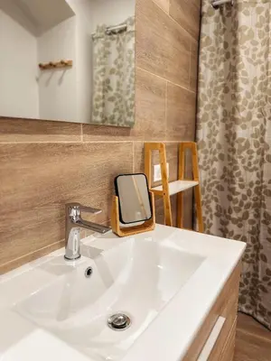 a bathroom with a white sink and a mirror at Cosy Cœur Alpilles, T2 neuf in Aureille