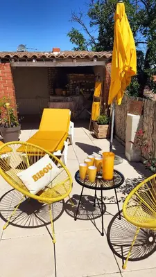 a patio with a yellow table and chairs and an umbrella at Escale vélo La petite Reine in Cavaillon