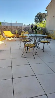 a patio with tables and chairs and a table and chairs at Escale vélo La petite Reine in Cavaillon