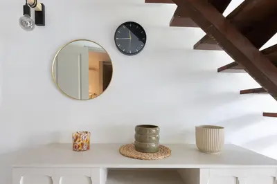 a mirror and a clock on a white wall at Le Duplex des Ocres - 2 bedrooms - Air conditioning - WiFi in Apt