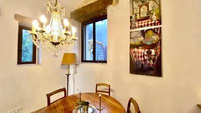a dining room with a wooden table and chairs at La Mistraline, in the center of the Luberon, Provence 2 bedroom, 2 bath Village House in Caseneuve