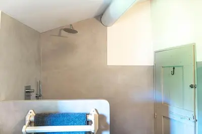 a bathroom with a shower and a blue bench at Chez Marthe - Maison de village - Ménerbes centre in Ménerbes