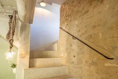 a set of stairs in a room with a stone wall at Chez Marthe - Maison de village - Ménerbes centre in Ménerbes