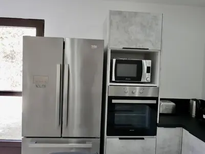a kitchen with a stainless steel refrigerator and a microwave at Les Calanques - Mas des Sous-Bois in Ventabren