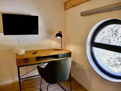 a desk with a chair next to a round window at Les Calanques - Mas des Sous-Bois in Ventabren