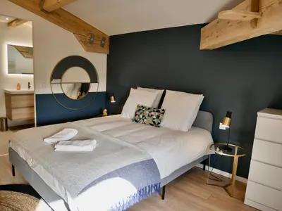 a bedroom with a large bed with a blue wall at Les Calanques - Mas des Sous-Bois in Ventabren