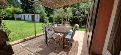 a patio with a table and chairs on a deck at Villa Rosa peaceful haven 10m from Aix 11 guests in Aix-en-Provence