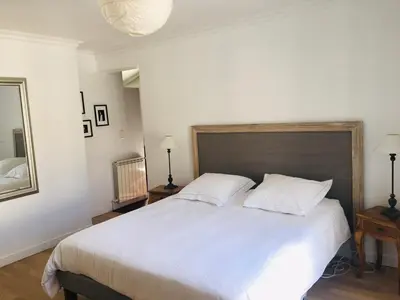 a bedroom with a large white bed and a mirror at Provencal villa with pool and large terrace in Rognac