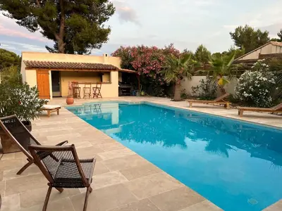 a swimming pool with two chairs and a house at Provencal villa with pool and large terrace in Rognac