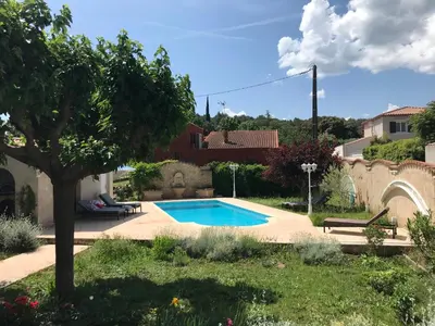 a swimming pool in a yard with a tree at Joli rez de villa proche d'Aix-en-Provence in Peyrolles-en-Provence