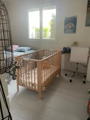 a crib in a room with a desk and a window at Joli rez de villa proche d'Aix-en-Provence in Peyrolles-en-Provence