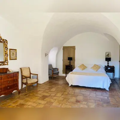 a bedroom with a bed and a desk and a chair at Bastide de Bénezet in Mérindol