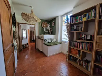 a hallway with bookshelves and a room with a window at Magnifique maison de ville avec piscine au cœur de la Provence in Salon-de-Provence