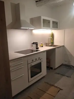 a kitchen with white cabinets and a stove top oven at Maison de Charme Rénovée 3 Chbres Hyper Centre Historique in LʼIsle-sur-la-Sorgue