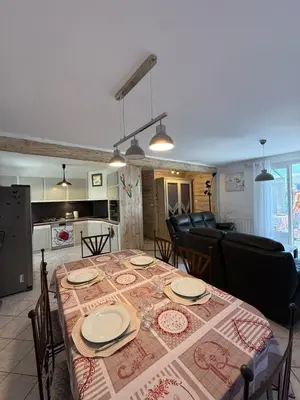 a dining room with a table and chairs and a kitchen at Maison Tamaris in LʼIsle-sur-la-Sorgue
