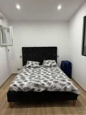 a bedroom with a bed with a black and white comforter at Mas des trois sautets in Meyreuil