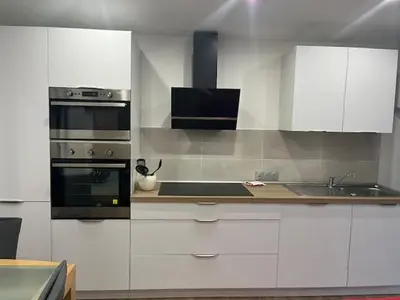 a kitchen with white cabinets and a stove at Mas des trois sautets in Meyreuil