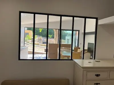 a room with a large window with a table and chairs at Mas des trois sautets in Meyreuil