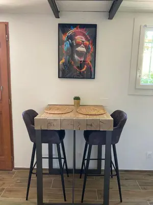 a table with two chairs and a painting on the wall at Les Elles du Moulin Avec Piscine in Vedène