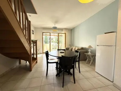 a kitchen and dining room with a table and a refrigerator at résidence avec piscines à proximité de Gordes in Gordes