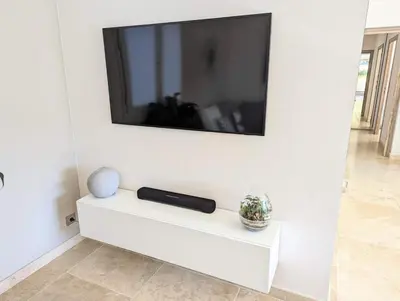 a flat screen tv on a white wall at Villa haut de gamme avec piscine et grand jardin in Aix-en-Provence